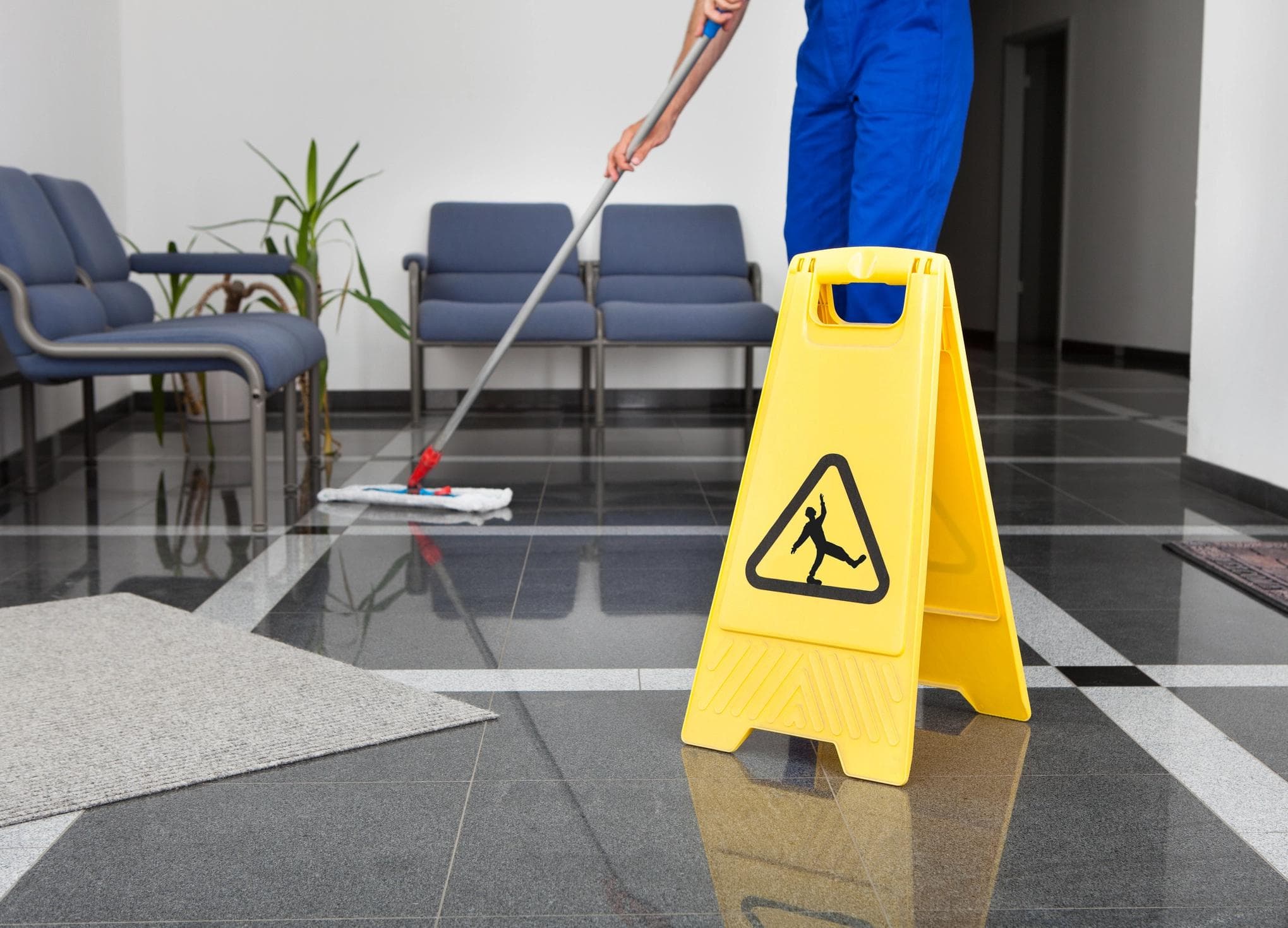 Employee mopping a glossy floor.
