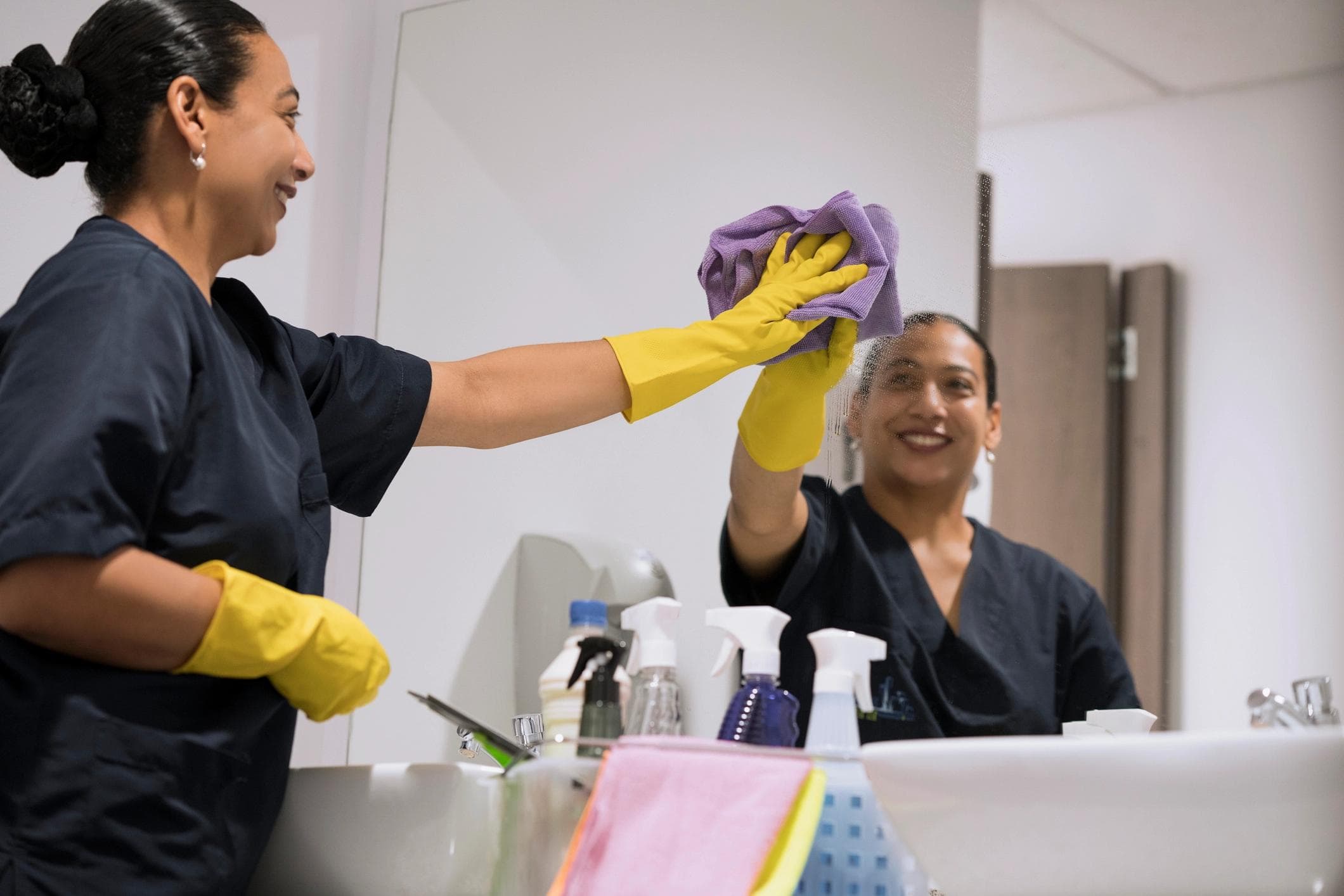 Employee cleaning a mirror.